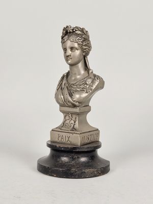 a silver statue of a woman with a wreath on her head