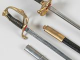 two swords and a sword are laying on a white surface