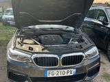 a bmw car with its hood open in a parking lot