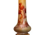 un vase orné d'une peinture posé sur une surface blanche