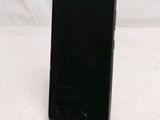 a close up of a cell phone on a stand on a white surface
