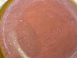 a brown vase with writing on it sitting on a table