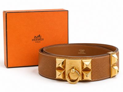 une ceinture en cuir marron avec une boucle dorée et une boîte