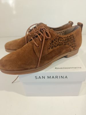 a pair of tan sued shoes on a white box