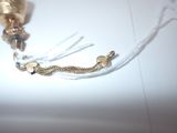 a gold bell with a chain attached to it on a table