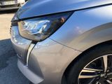 the front end of a silver car with a denting dent on it ' s bumper