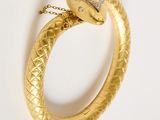 an image of a gold snake ring with a pink stone in the middle
