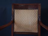a wooden chair with a tan seat and a black background