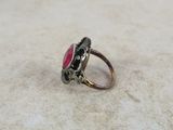 an image of a ring with a red stone in it