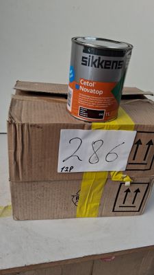 un pot de peinture posé sur une boîte en carton