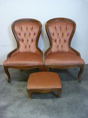 deux chaises et un pouf dans une pièce aux murs blancs