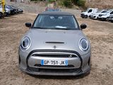 a silver mini car parked in a lot with other cars