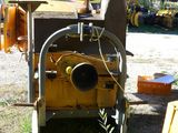 a machine that is sitting in the grass near a tree