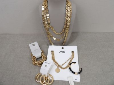 des colliers, des bracelets et des boucles d'oreilles en or exposés sur une table