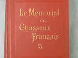 un livre rouge avec des lettres dorées posé sur une surface blanche