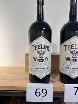 deux bouteilles de whisky posées l'une à côté de l'autre sur une étagère