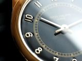 a close up of a gold wrist watch with a black face
