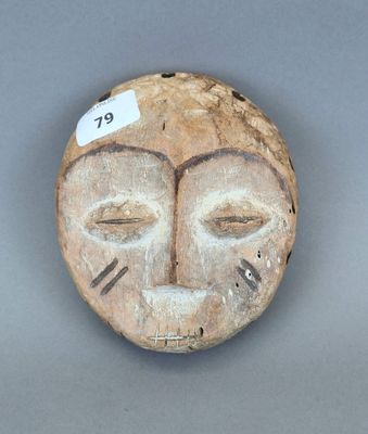 une image représentant un masque en bois sur lequel est accrochée une étiquette