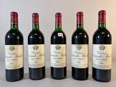 quatre bouteilles de vin rouge sont alignées sur une table
