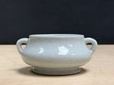 a small white bowl sitting on a wooden table