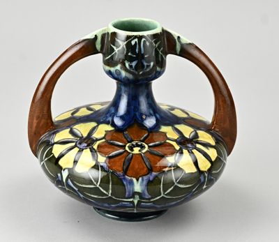 un vase bleu et vert muni d'une poignée en bois sur fond blanc