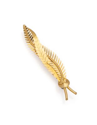 a close up of a gold leaf brooch on a white background
