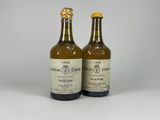 deux bouteilles d'alcool posées l'une à côté de l'autre sur une surface blanche