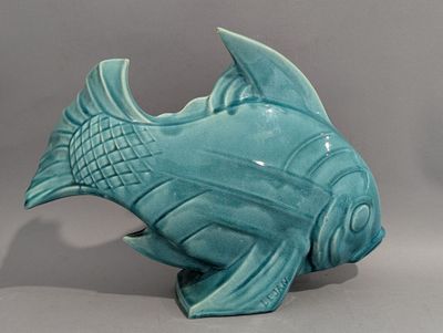 un poisson en céramique bleue posé sur une table