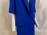 un gros plan sur un mannequin vêtu d'un costume bleu, posé sur un socle blanc