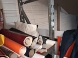 many rolls of fabric on a shelf in a garage