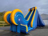 un toboggan aquatique gonflable bleu et jaune dans un parking