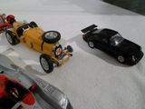 trois petites voitures posées sur une surface blanche