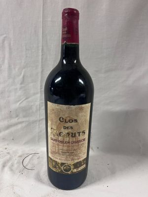 a bottle of red wine sitting on top of a white table