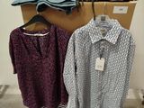 two shirts hanging on a rack in a room