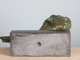 sculpture of a green pepper sitting on top of a wooden block