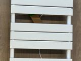 une horloge accrochée au mur à côté d'un radiateur