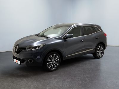 a grey car is parked in a room with a white wall