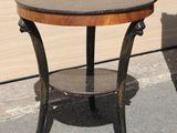 a small round table with a wooden top on the sidewalk