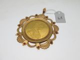 un gros plan d'une pièce d'or posée sur une surface blanche, avec une étiquette de prix