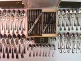 a lot of spoons and spoon knives on the table
