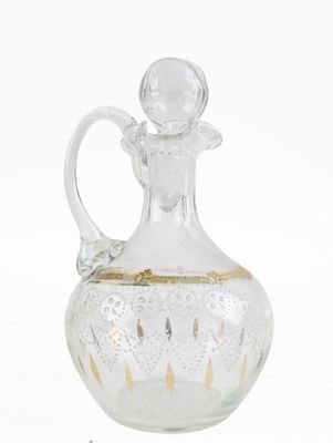 a glass decanter with a gold decoration on it