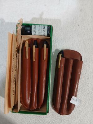 une boîte de stylos et deux étuis en cuir