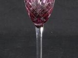 purple wine glass on a black table with a black background