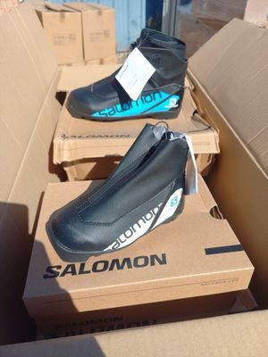 trois paires de chaussures posées sur une boîte en carton