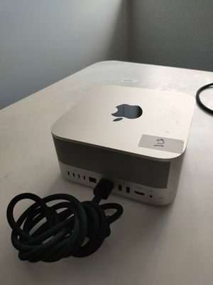 a white apple computer sitting on a table with a charger