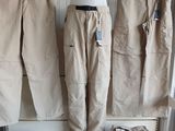 three pairs of khaki pants hanging on a rack in a clothing store