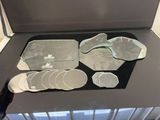 un plateau en verre sur lequel sont posés de nombreux dessous de verre et une paire de tongs