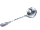 une cuillère en argent avec un manche de cuillère sur une surface blanche