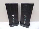 two black speakers sitting on top of a white table