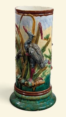 un vase avec un oiseau posé sur une table